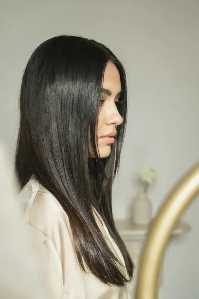 Sleek Black Straight Blowout With Long Face-Framing Layers And Glossy Finish